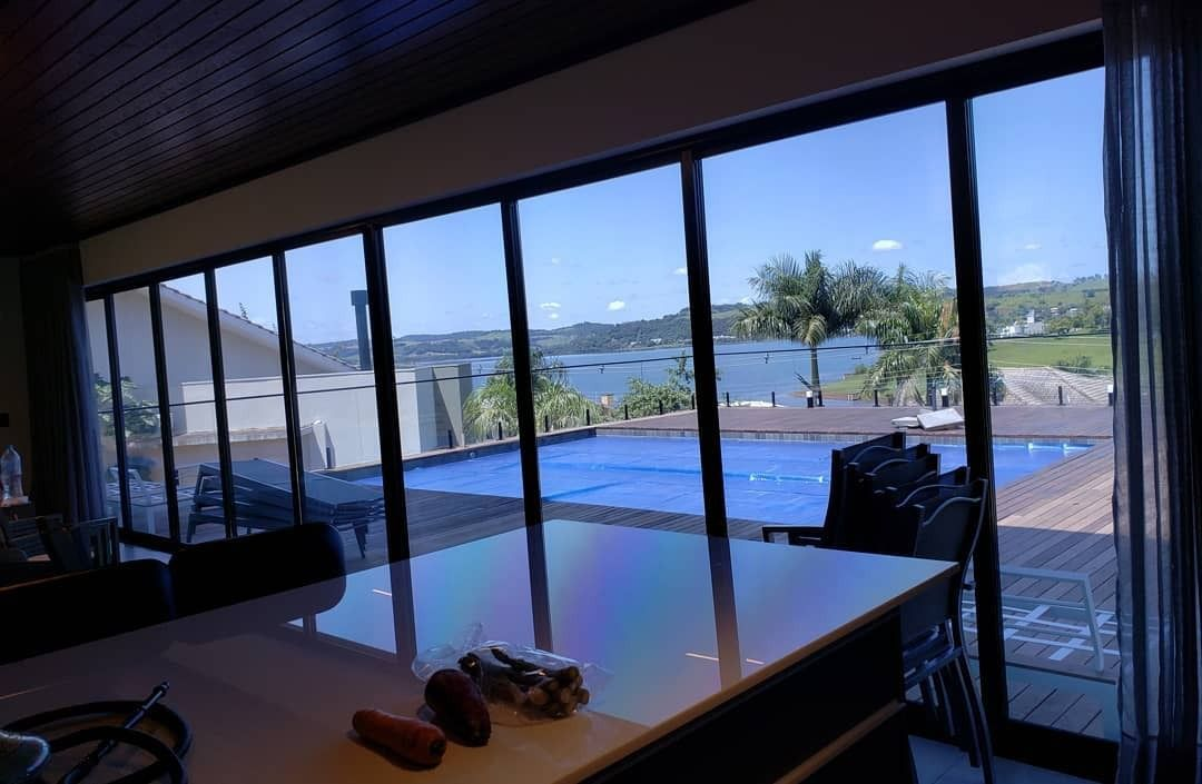 Interior com vista para piscina através de vidros com película